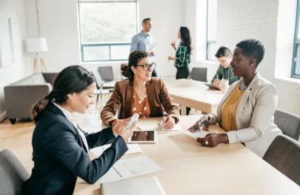Group of employees sit around a conference table, representing Beacon Hill has been ranked #15 among the largest finance and accounting staffing firms in the U.S. for the eighth consecutive year by Staffing Industry Analysts.