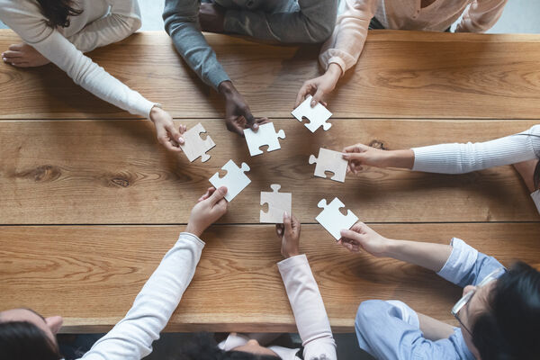 Team collaborating to assemble puzzle pieces, representing contingent workforce supplier management and MSP oversight in 2026
